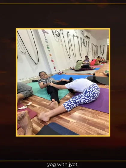 A student practices a seated forward bend with partner assistance to deepen the hamstring stretch.