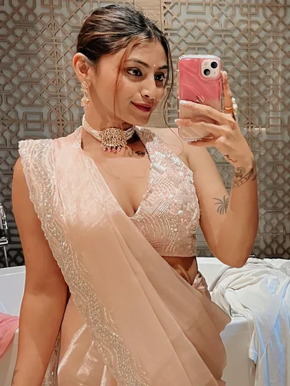 One last selfie before heading out. The combination of the soft pink saree, the detailed blouse, and the statement choker creates a complete and polished festive outfit.