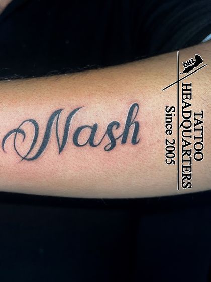 The name "Nash" in a clean, elegant cursive script, a classic and timeless name tattoo.