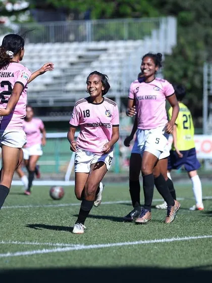Players celebrating a goal, a moment of shared success on the field.