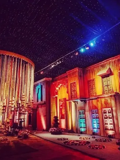 A shot from one of my large-scale productions, showcasing a recreated street scene with dramatic lighting and a massive hanging installation of bells and candles.