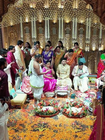 The couple and their family during the wedding ceremony inside the grand, traditionally designed mandap.