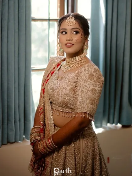 A three-quarter portrait of the bride, capturing her complete look by the window.