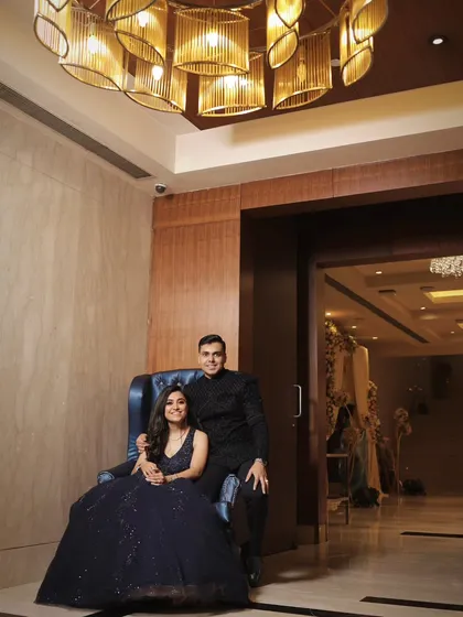 A stylish portrait of the engaged couple, using the venue's modern chandelier and interior design to create a sophisticated and memorable photograph.