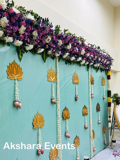 A side view of the elegant mint-colored backdrop, showing the colorful floral garland border and the hanging lotus details.