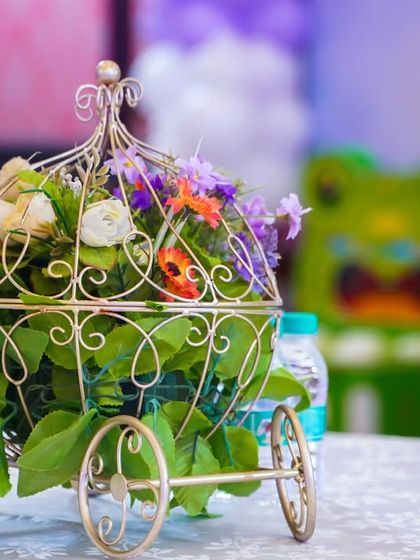 An elegant floral centerpiece in a golden carriage, a beautiful detail for a princess-themed table setting.