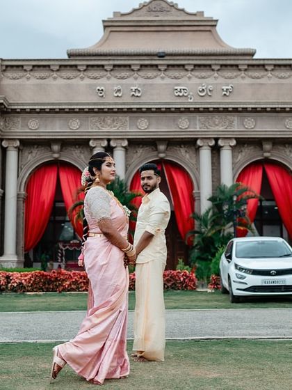 A stylish portrait of a couple in front of a grand building, capturing a modern yet traditional feel.