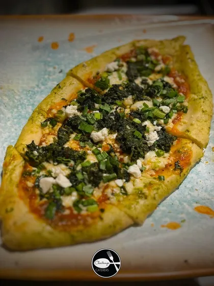My Turkish Pide is a fantastic alternative to traditional pizza. This boat shaped flatbread has a crispy crust and a soft interior, topped with fresh herbs, cheese, and greens for a light yet flavourful option.