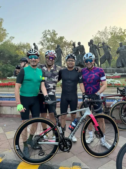 Four of our dedicated members posing with a sleek Cannondale road bike.