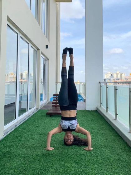 Taking the practice outside. An inversion on a balcony is a reminder that you can find a new perspective anywhere. Upside down is the new normal.