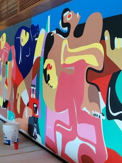 A work-in-progress shot of the colorful, abstract mural, showcasing the vibrant palette before the final details are added.
