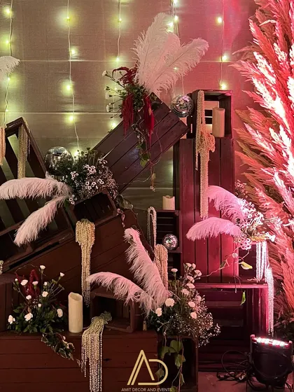 I love creating artistic installations with everyday objects. Here, stacked wooden crates are adorned with white ostrich feathers, baby's breath, and disco balls for a touch of glam.