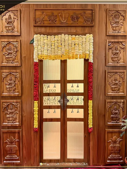 An example of my dedication to traditional craftsmanship, this magnificent wooden puja room door is adorned with intricate carvings of deities. The design is complemented by festive marigold garlands, creating a truly sacred and welcoming entrance.