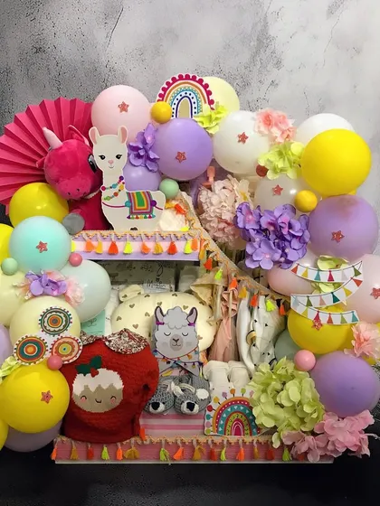 This multi-level 'No Drama Llama' trousseau is perfect for displaying a variety of gifts, from clothes and toys to baby care products, all tied together with a fun, vibrant theme.