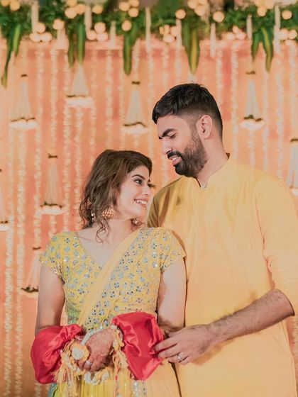 A sweet moment between the couple, coordinated in yellow, perfectly matching the Haldi theme.