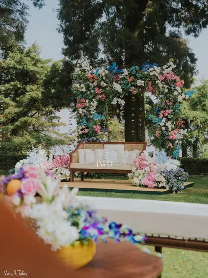 A lovely seating spot for the couple at the Mussoorie Mehendi, framed by a floral arch that complements the natural beauty of the surroundings.
