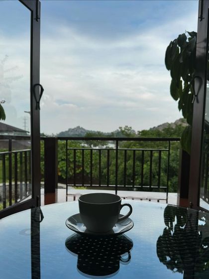 A cup of herbal tea on a balcony table, overlooking the hills. Simple moments like this, combining nourishment with a beautiful view, are a key part of the de-stressing experience.