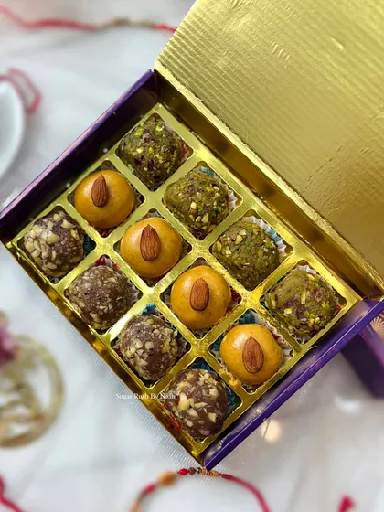 A close-up of 'The Sweet Box' for Rakhi, showcasing the Pista Mafroukeh, Hazelnut Mafroukeh, and Besan Ladoo with Dark Chocolate Ganache.