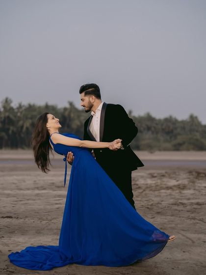 A dance on the beach. This couple's pre-wedding photo is full of movement and romance, featuring a gorgeous royal blue gown.