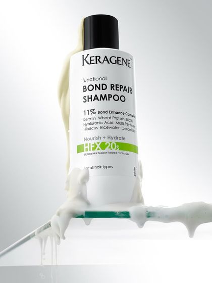 A creative shot of bond repair shampoo with a thick, creamy product smear. The composition highlights the product's rich texture.