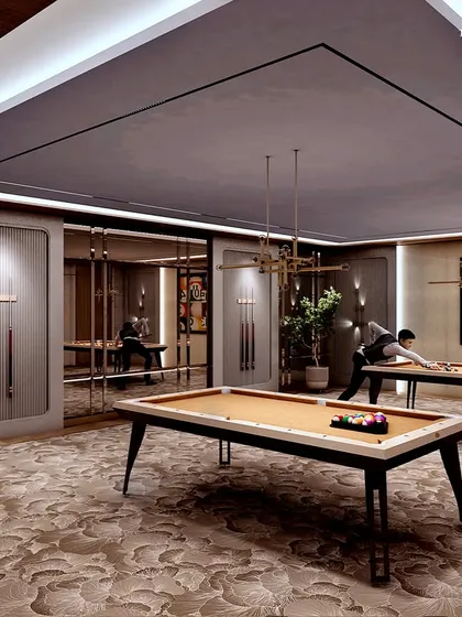 A sophisticated billiards room within the sports club, featuring two pool tables set on a plush, patterned carpet. The room is designed for focused competition in a stylish and comfortable setting.