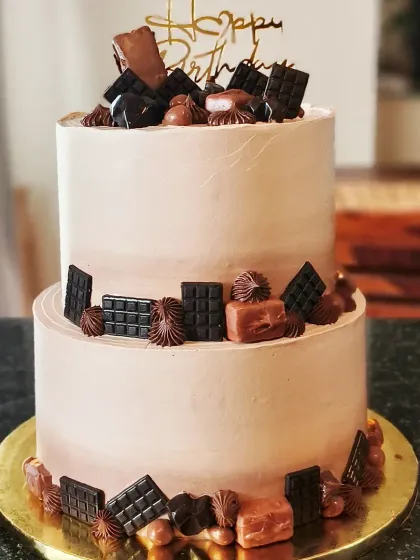 A chocolate lover's dream come true. This two-tier chocolate truffle cake is loaded with an assortment of mini chocolate bars and candies. It’s a rich, decadent choice for any birthday or special occasion.