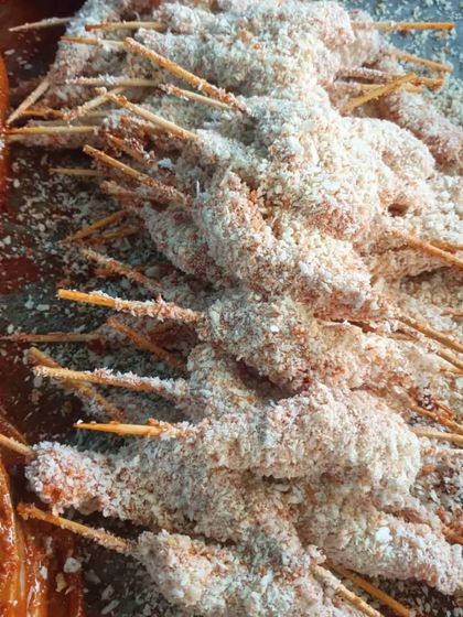 Chicken lollipops coated in a breadcrumb mixture, ready to be deep-fried until golden and crispy. A popular choice for birthday parties.