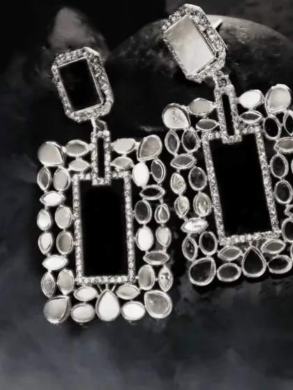 To give fashion accessories a high-end, editorial feel, I play with dramatic lighting and textures. These intricate earrings are set against dark, smoky stones, making the craftsmanship and reflective surfaces stand out.
