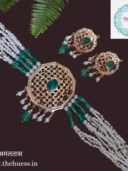The 'अमलतास' (Amaltas) necklace set, a stunning Hyderabadi choker with a large central motif and emerald green beads. This piece is the epitome of royal elegance.