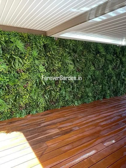 A full-coverage artificial green wall installed on a covered patio, seamlessly blending the indoor and outdoor space with vibrant, year-round greenery.
