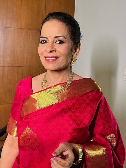 The real women who run the show. This beautiful mother of the bride is glowing in a classic red saree, her makeup kept elegant and timeless.
