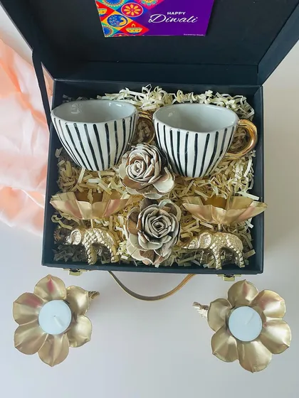 Here you can see the beautiful golden elephant T-light holders that come with the striped ceramic cups. They add a touch of royal elegance to this Diwali suitcase hamper.
