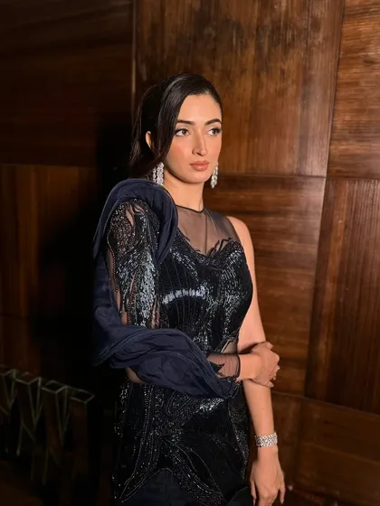 Serving glam with a touch of sass. This cocktail makeup look is all about bling on the eyes, glossy lips, and a flawless glow, perfect for a night of dancing in this stunning blue and black gown.
