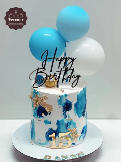 A blue and white abstract cake decorated with balloons. This simple design is vibrant and celebratory, perfect for a 15th birthday.