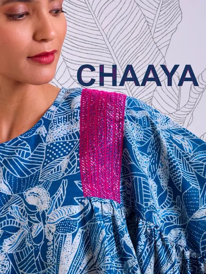 A close-up of the shoulder detail on our Chaaya oversized top. The pop of pink hand embroidery adds a vibrant contrast to the deep indigo block print.