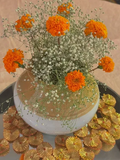 A simple yet elegant centerpiece combining locally sourced marigolds with delicate baby's breath. Using seasonal flowers is a core part of my eco-friendly approach, ensuring freshness while supporting local growers.