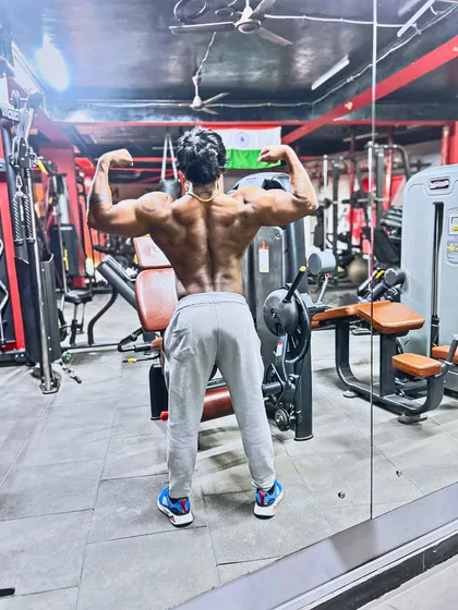 A back double bicep pose in the mirror. Checking the progress of my back development.