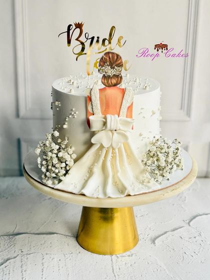 A beautiful cake for a bride-to-be. This design features an elegant illustration of a bride in her gown, with delicate baby's breath adding a touch of softness.