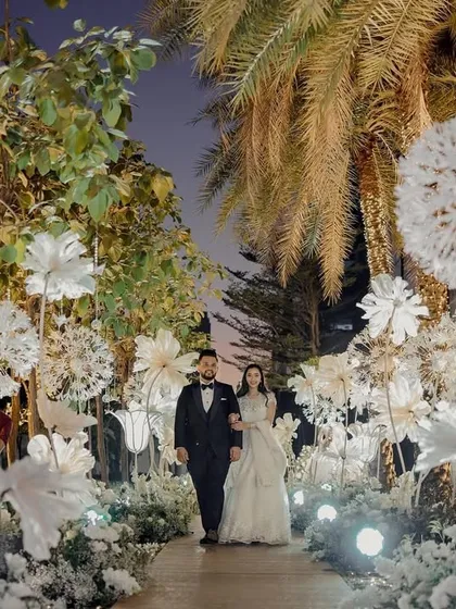 Miloni and Yash walk through 'A White Wonderland' we created for their special night. The pathway is lined with larger-than-life, handcrafted origami flowers and dandelions, creating a serene and enchanting atmosphere that felt like a dream.
