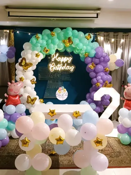 A full view of the Peppa Pig themed second birthday, showing the balloon arch, character foils, and room layout.