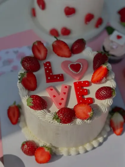 A fresh and lovely Valentine's cake, topped with juicy strawberries and the word "LOVE".