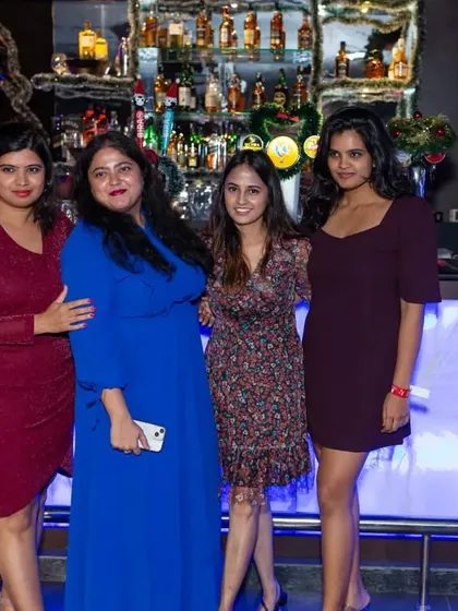 A group of ladies posing in front of the bar during the holidays.