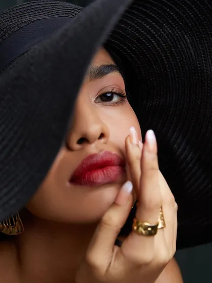 A tight close-up focusing on the model's expression and makeup. In fashion photography, these detail shots are crucial for showcasing beauty and accessory elements.