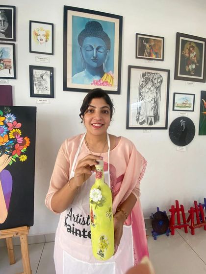 A participant with her finished decoupage bottle. The vibrant yellow and floral design make it a cheerful and eye-catching piece.