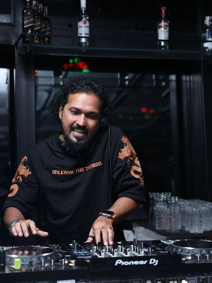 Focused on the controls, ensuring a seamless transition between tracks to keep the party momentum going.