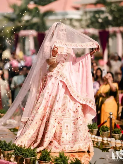 A bride's walk towards her future is a story in itself. Archana, a vision in pink, floats down the aisle under a shower of petals, her grace and beauty captivating everyone, especially the groom waiting for her.