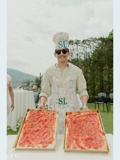The groom himself, showing off the pizzas he made at the fun-filled DIY party.