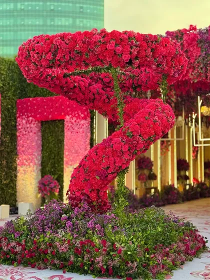 A close-up of the swirling red floral sculpture. The sheer volume of flowers used creates a powerful and unforgettable visual impact.