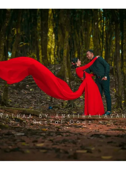 This dramatic red rental gown, with its long, flowing trail, is one of my most popular pieces for pre-wedding photoshoots. It creates stunning, cinematic shots against natural backdrops like this forest setting.