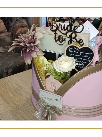 A detailed shot of a 'Bride-to-be' hamper, showing the arrangement of gifts, including a custom photo frame and a mini chalkboard for sweet notes.